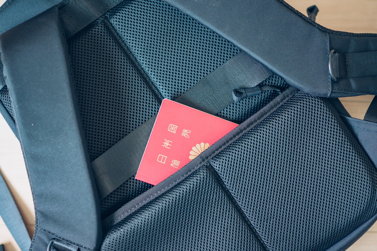 HOLICC One miniの収納ポケットにパスポートをしまう様子