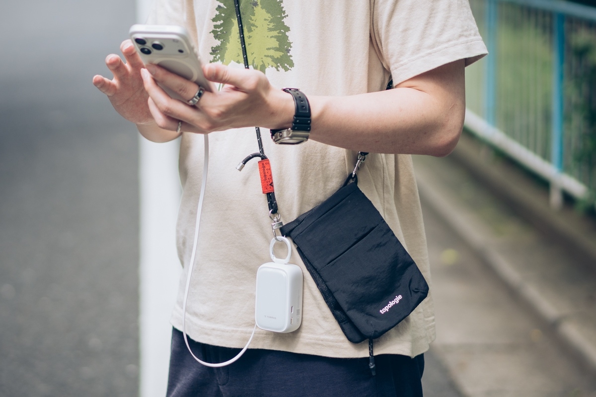 PearlGo 2in1をリュックのショルダーベルトにカラビナで吊るし、内蔵ケーブルを伸ばして充電する様子